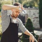 Жена се държи за главата от световъртеж при рязко изправяне в горещ ден