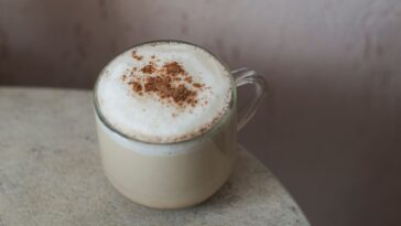 Чаша топло мляко с канела на дървена маса