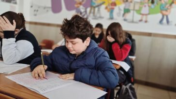 Ученик се подготвя за изпит с учебници на масата