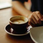 Чаша кафе на бюро до човек, изглеждащ напрегнат